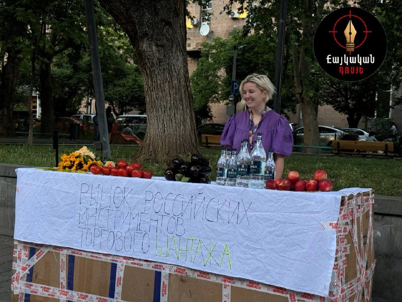 Инсталляция на Вернисаже в Ереване: помидоры, баклажаны, цветы и бутылки Джермука с плакатами о торговом шантаже